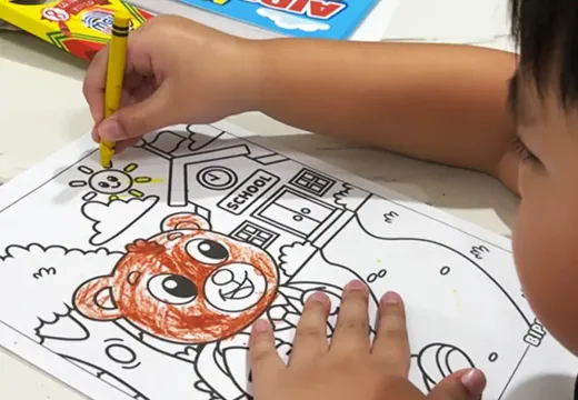 A child coloring the bear design with crayons