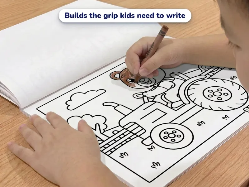 Child with a crayon coloring a picture of a bear farmer driving a tractor
