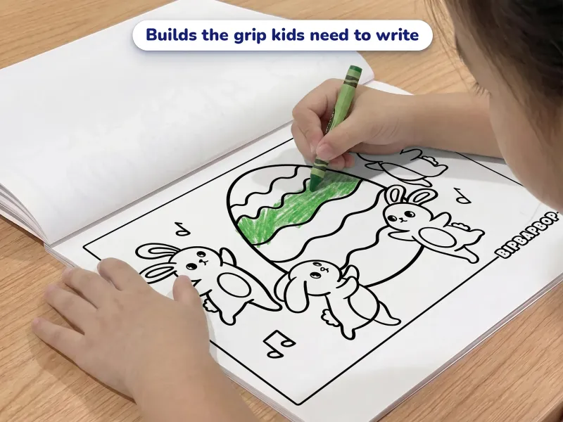 Child with a crayon coloring a picture of rabbits dancing round an easter egg