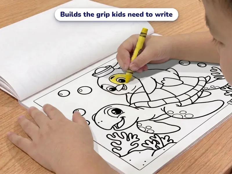 Child with a crayon coloring a picture of a penguin riding a turtle